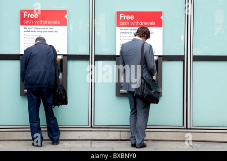 Gli uomini al Bancomat della banca HSBC in London, England, Regno Unito, Europa Foto Stock