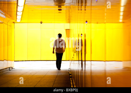 Uomo che cammina attraverso un sottopassaggio in London, England, Regno Unito, Europa Foto Stock