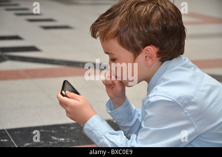 Ragazzo giovane pensando prima di fare la sua prossima mossa Foto Stock