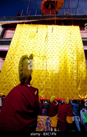 I monaci arrotolamento di un gigantesco thangka e portandolo su off per la memorizzazione Foto Stock