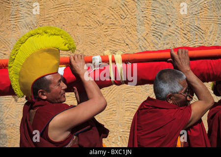 I monaci arrotolamento di un gigantesco thangka e portandolo su off per la memorizzazione Foto Stock