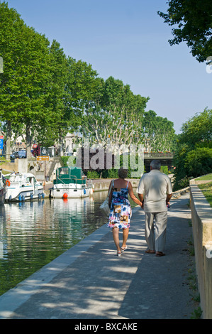 Coppia di anziani camminando sul percorso lungo il Canal de la Robine passando attraverso Narbonne Francia Foto Stock