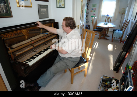 Sintonizzazione di un pianoforte verticale su una casa privata Foto Stock