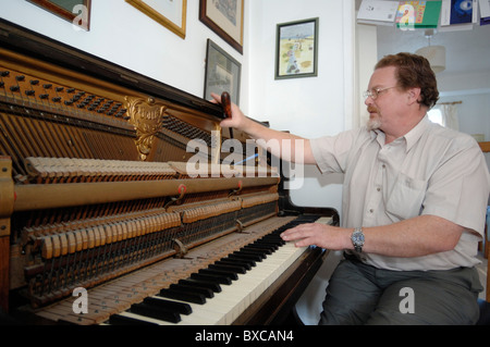 Sintonizzazione di un pianoforte verticale su una casa privata Foto Stock