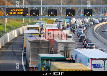 M25 Autostrada del traffico di accodamento dietro incidente riportato sul tettuccio di segni del gantry Foto Stock