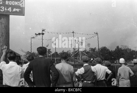 Cinque intrepidi volantini di eseguire durante il Circus carnaval 1920 S 1930 entertainment guardando pubblico viaggia trapezio la moda Foto Stock