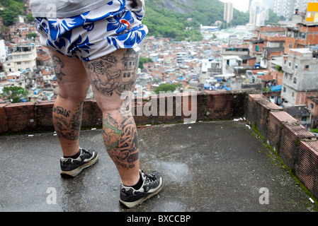 Tatuaggi raffiguranti Rocinha Favela sulle gambe di DJ Zezinho a Rio de Janeiro in Brasile Foto Stock