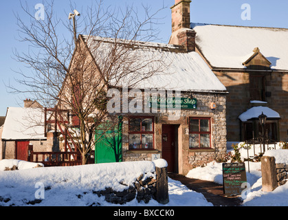 Hartington, Derbyshire, Inghilterra, Regno Unito. Il vecchio negozio di formaggi locali di vendita i formaggi del Dovedale village con la neve in inverno Foto Stock