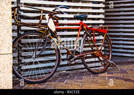 Il vecchio stile bicicletta parcheggiata sul marciapiede Foto Stock