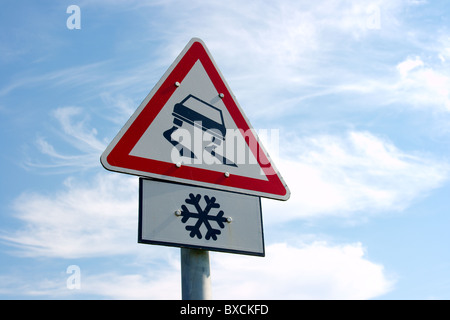 Segno di traffico mette in guardia su strada sdrucciolevole in anticipo Foto Stock