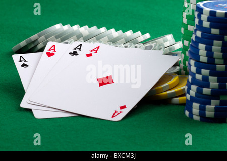 Mano di Poker di 4 assi e poker chips sul feltro verde