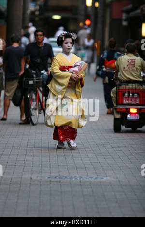 Una maiko geisha camminando alla sua nomina in una casa da tè sulla street nel quartiere di Gion a Kyoto in Giappone Foto Stock