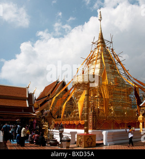 Fedeli in preghiera presso il golden chedi di Wat Phra That Doi Suthep a Chiang Mai in Thailandia Foto Stock