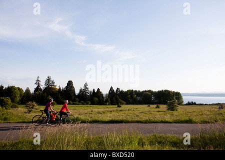 Due giovani donne godono ther vista sulla corsa a casa dal lavoro attraverso un parco. Foto Stock