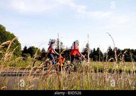 Due giovani donne godono ther vista sulla corsa a casa dal lavoro attraverso un parco. Foto Stock