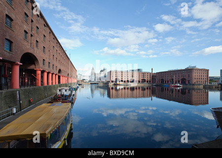 Albert Dock Liverpool Merseyside con il blu del cielo e delle nubi riflessi nell'acqua, nella distanza è il famoso Liverbuildings. Foto Stock