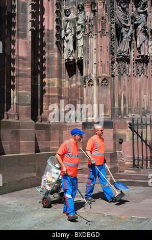 Due pulitori di strada cucciolata di spazzamento di fronte cattedrale di Strasburgo, Alsazia, Francia; l'Europa Foto Stock