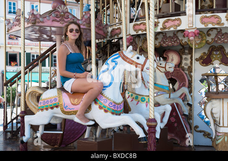 Giovane donna sulla giostra bianco del cavallo di legno Strasburgo Alsace Francia Foto Stock