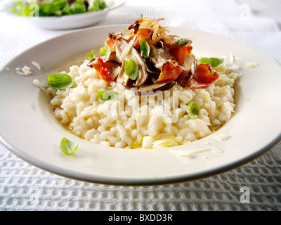 Risotto classico selvaggio con funghi porcini e pancetta Foto Stock