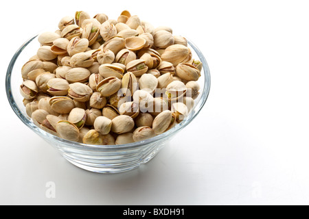 Pistacchi Noci in recipiente di vetro con sfondo bianco Foto Stock