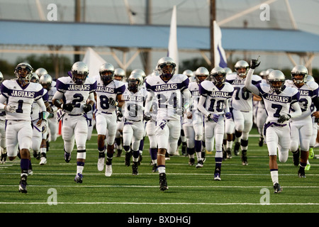 American high school football giocatori corrono verso il campo prima del calcio d'inizio a un gioco di Austin in Texas USA Foto Stock