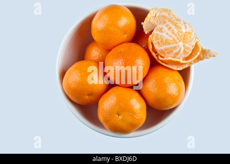 Le clementine in vaschetta bianca sulla superficie bianca Foto Stock