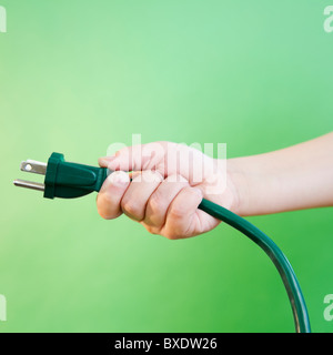 Mano che tiene il cavo elettrico Foto Stock