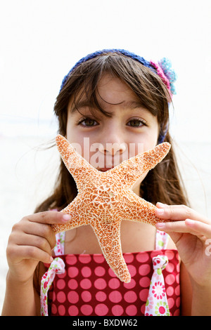 Ragazza ispanica holding starfish Foto Stock