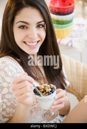 Brunette donna mangiare cereali e yogurt Foto Stock