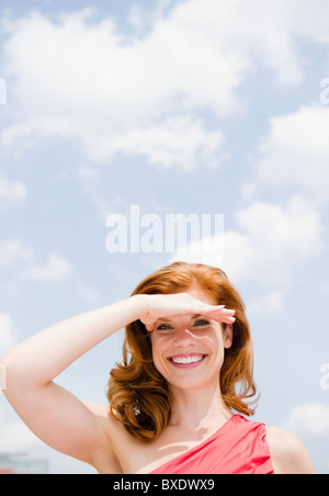 Bella donna di schermare gli occhi dal sole Foto Stock