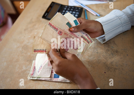 Un ragioniere conta in contanti (scellini tanzaniani) in Dodoma, Tanzania Africa Orientale. Foto Stock