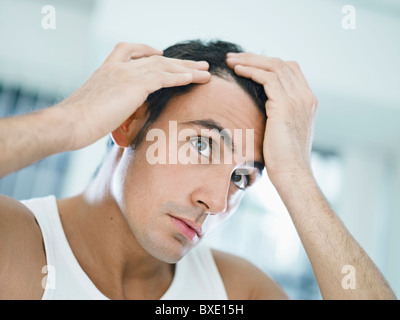 Caucasian uomo adulto controllo linea di demarcazione. Sagoma orizzontale, testa e spalle, vista frontale Foto Stock