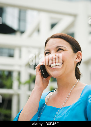 Sorridente imprenditrice parlando al cellulare Foto Stock