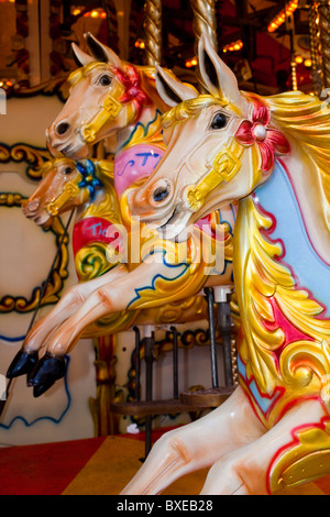 Giostra cavalli in legno su una fiera Merry Go Round, una tradizionale fiera ride per bambini Foto Stock