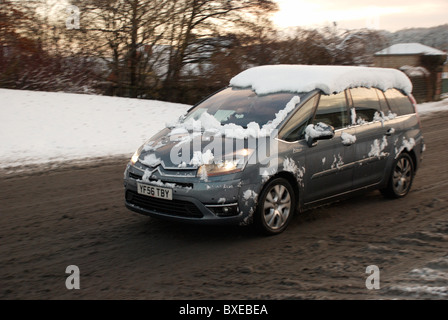 Auto rendendo il suo attraverso una scena nevoso. Citroën C4 Grand Picasso Foto Stock