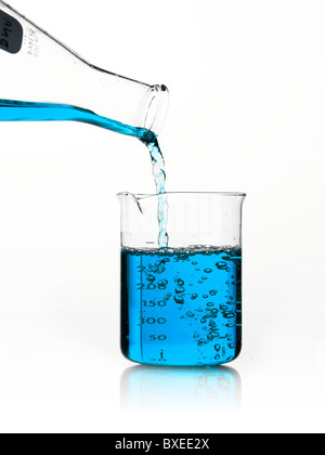 Blue il liquido viene versato in una coppa di misurazione Foto Stock