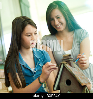 Madre e figlia di verniciatura di un birdhouse Foto Stock