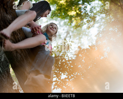 Due ragazze seduta in una struttura ad albero Foto Stock