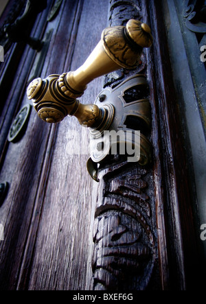 Ottone ornamentali maniglia della porta su weathered antica porta in legno di quercia Vienna Austria Foto Stock