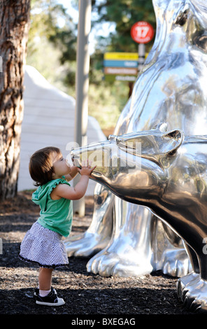 Una bambina baci di una statua di un orso polare in San Diego Zoo, arctic sezione. Foto Stock