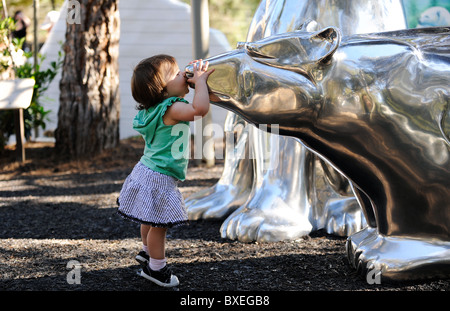 Una bambina baci di una statua di un orso polare in San Diego Zoo, arctic sezione. Foto Stock