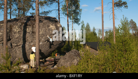 Un gruppo di alpinisti bouldering su di un enorme masso vicino a Oulu, Finlandia. Foto Stock