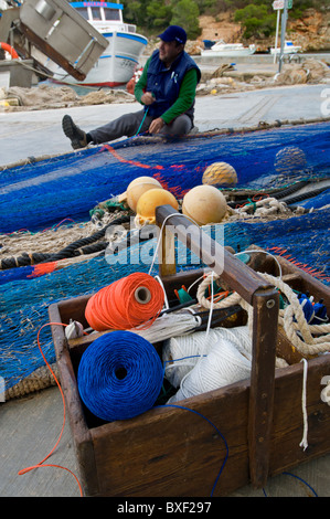 Pescatore di smistamento e riassettando le reti da pesca a Cala Figuera Mallorca Spagna Spain Foto Stock