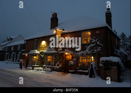 Una serata immagine del Jolly Il Cricketers villaggio locale pub di neve nel freddo invernale condizioni meteo al crepuscolo Foto Stock