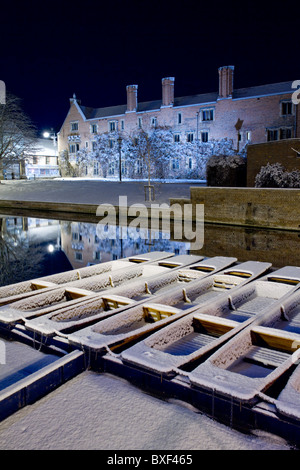 Coperte di neve sterline galleggiante sul fiume Cam in Cambridge di notte, con Magdalene College dietro Foto Stock