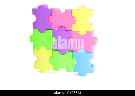 In plastica colorata puzzle blocchi su sfondo bianco Foto Stock