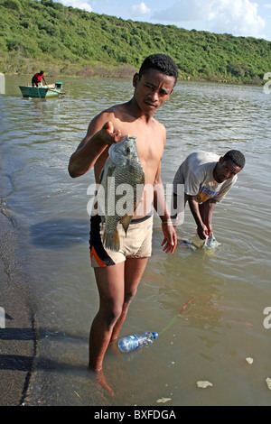 Pescatore locale azienda appena pescato il pesce Tilapia, Lago Chamo, Etiopia Foto Stock