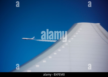 Passeggeri aerei jet visto attraverso il piano ala da oblò di un altro in volo sulla rotta verso l'America Foto Stock