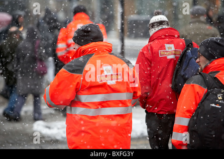 Royal Mail portalettere a passeggiare in un freddo inverni nevosi giorno Belfast Irlanda del Nord Foto Stock