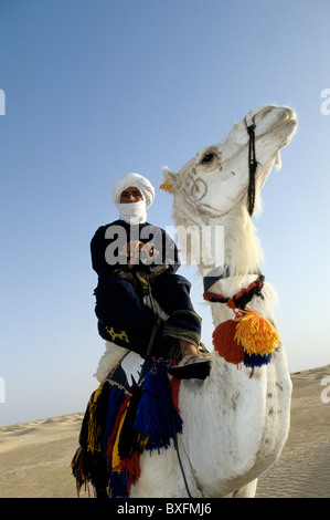 Uomo tunisino in cima a cavallo nel deserto del Sahara oasi cittadina di Tozeur - Tunisia. Foto Stock